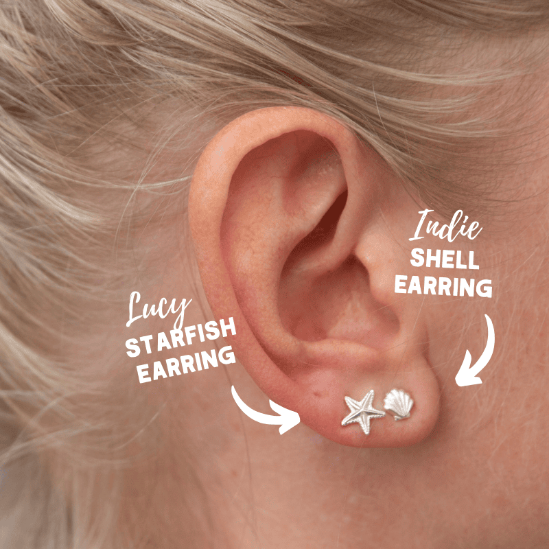 close-up on a womans ear wearing starfish stud and shell earring
