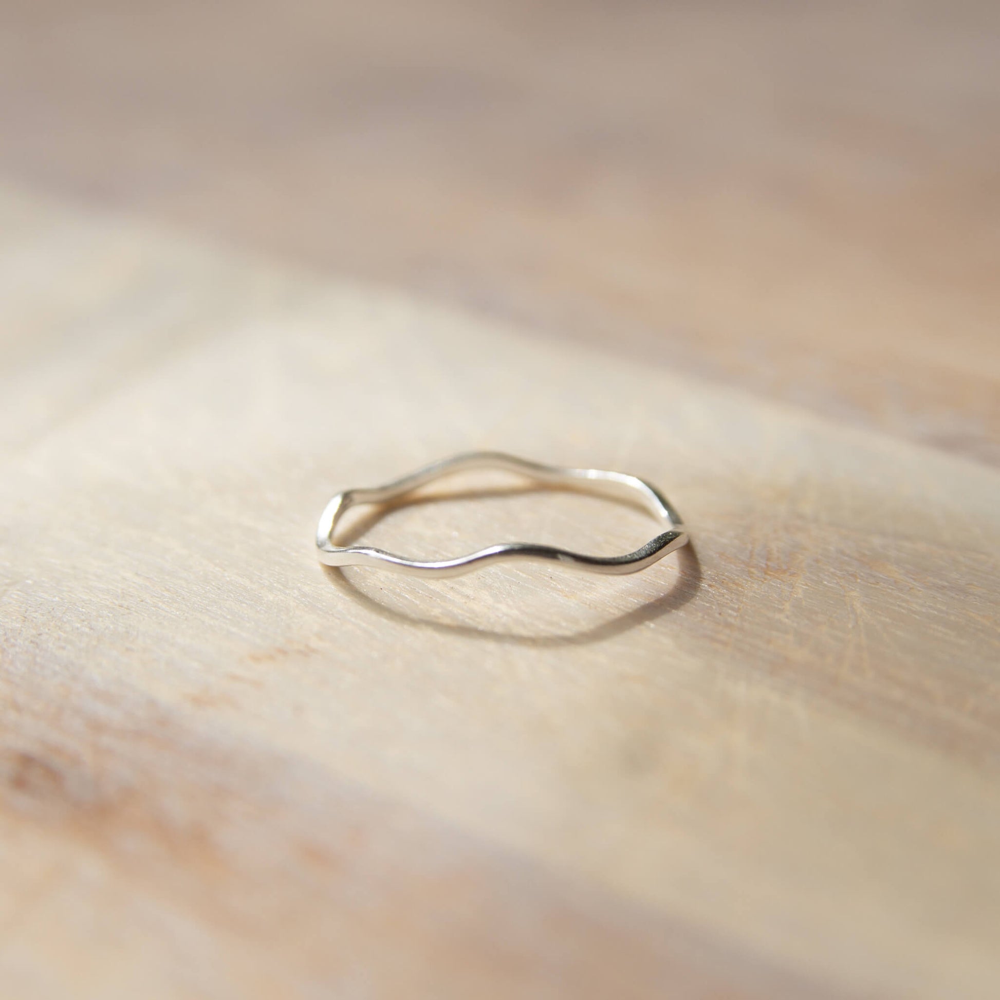 Sterling Silver Ripple Ring on a rock on a wooden table