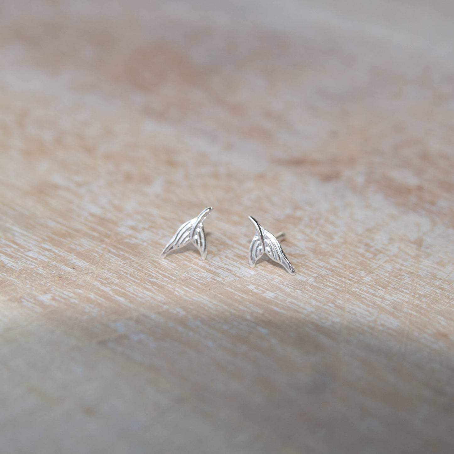 Sterling Silver Mermaid Tail Stud Earrings on a table