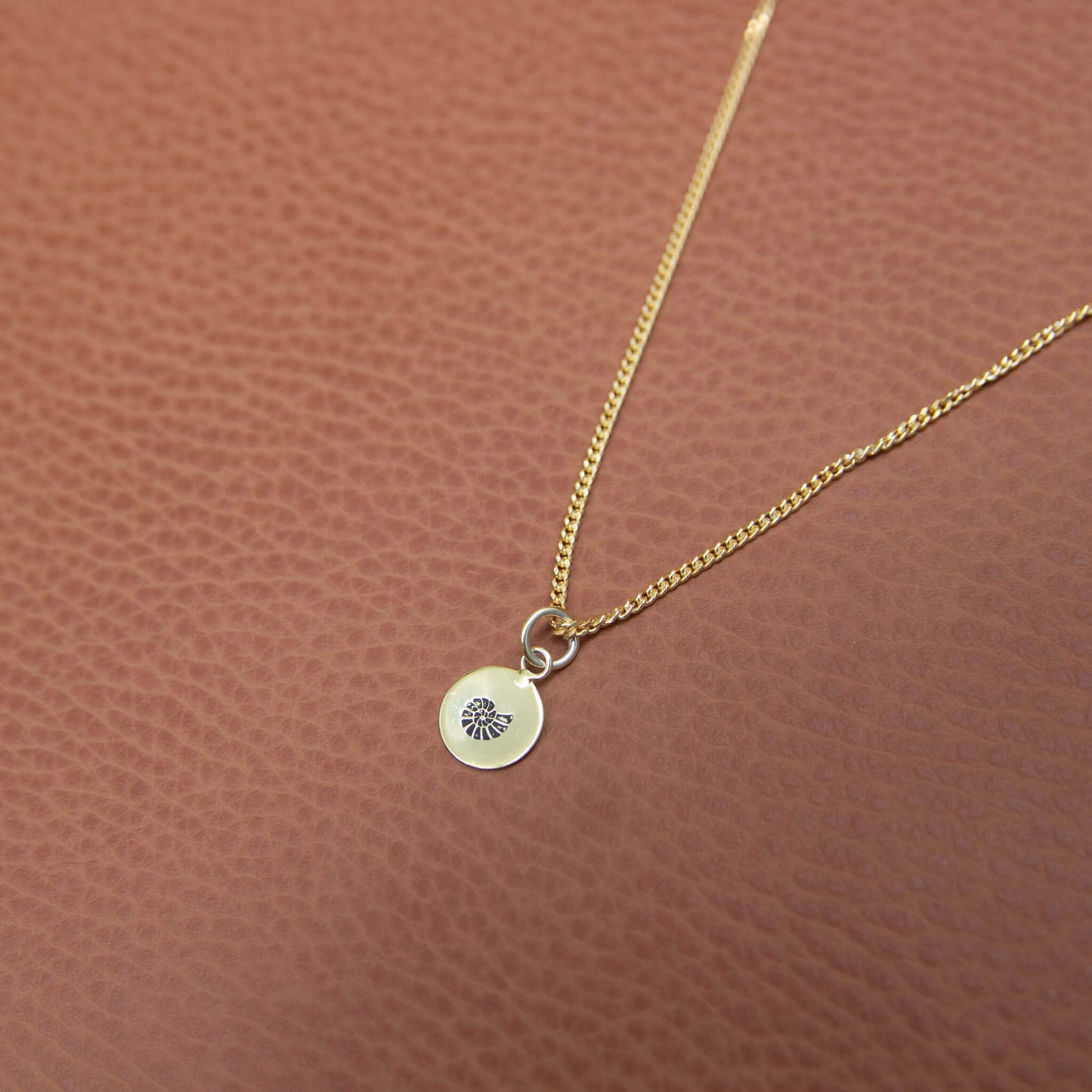 Gold Plated Shell Necklace on leather background