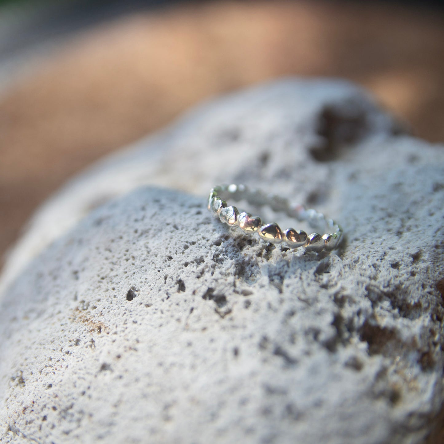 silver love heart necklace on a rock