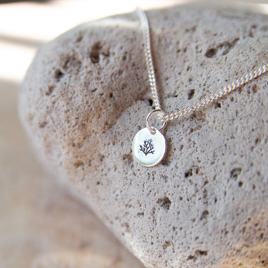 coral necklace placed on a rock