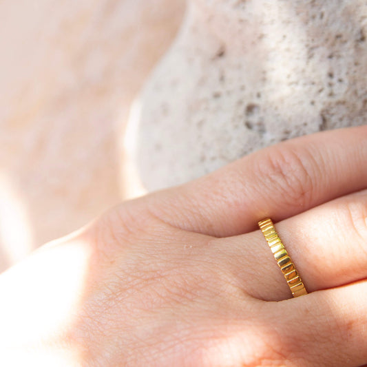 patterned gold plated ring on a finger