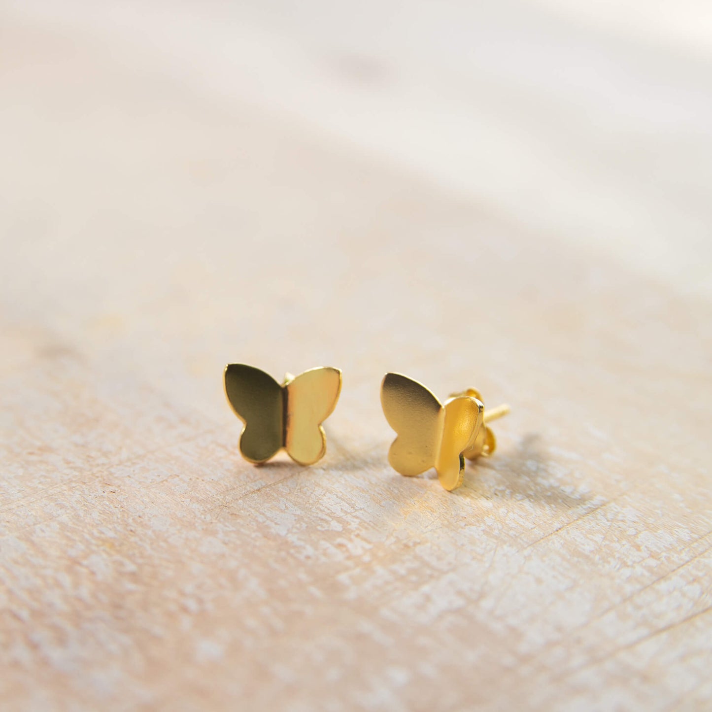 close-up of gold-plated butterfly earrings