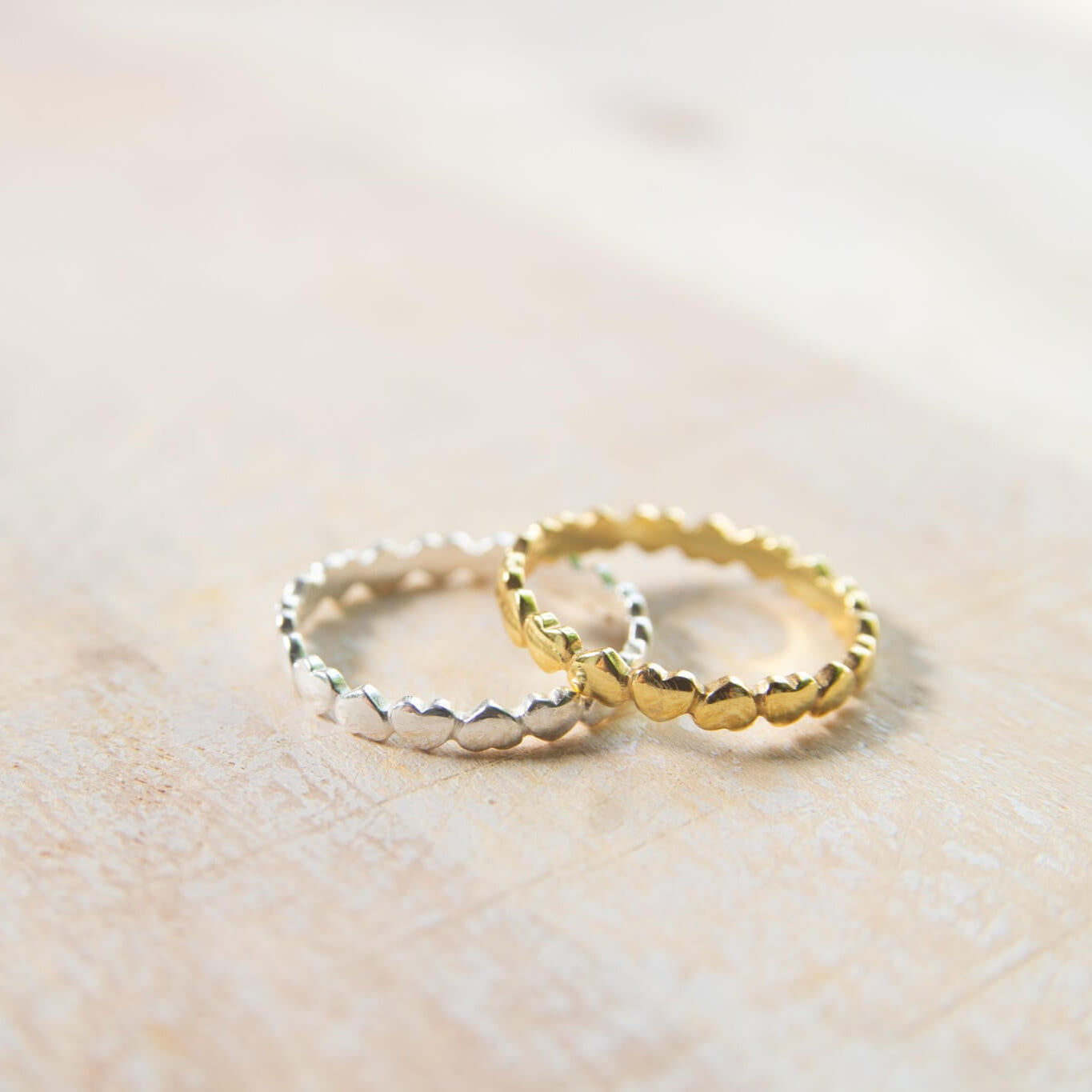 Gold and Silver Love Heart Rings on table