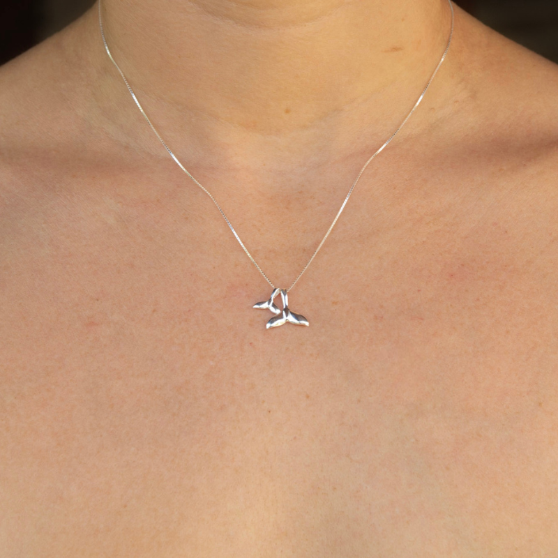 Silver necklace with a unique pendant on a person's neck