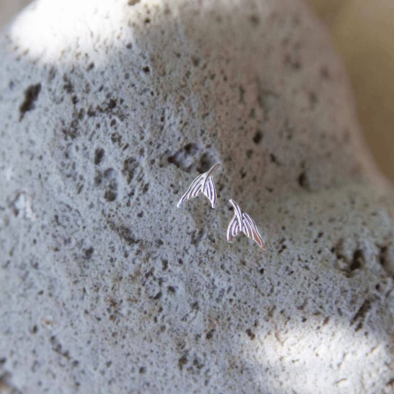 mermaid tail stud earrings on a rock