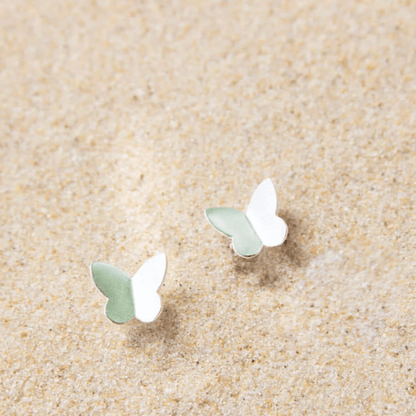 silver butterfly earrings in sand