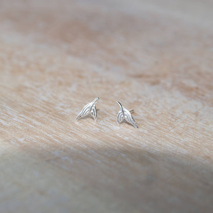 Sterling Silver Mermaid Tail Stud Earrings on a table