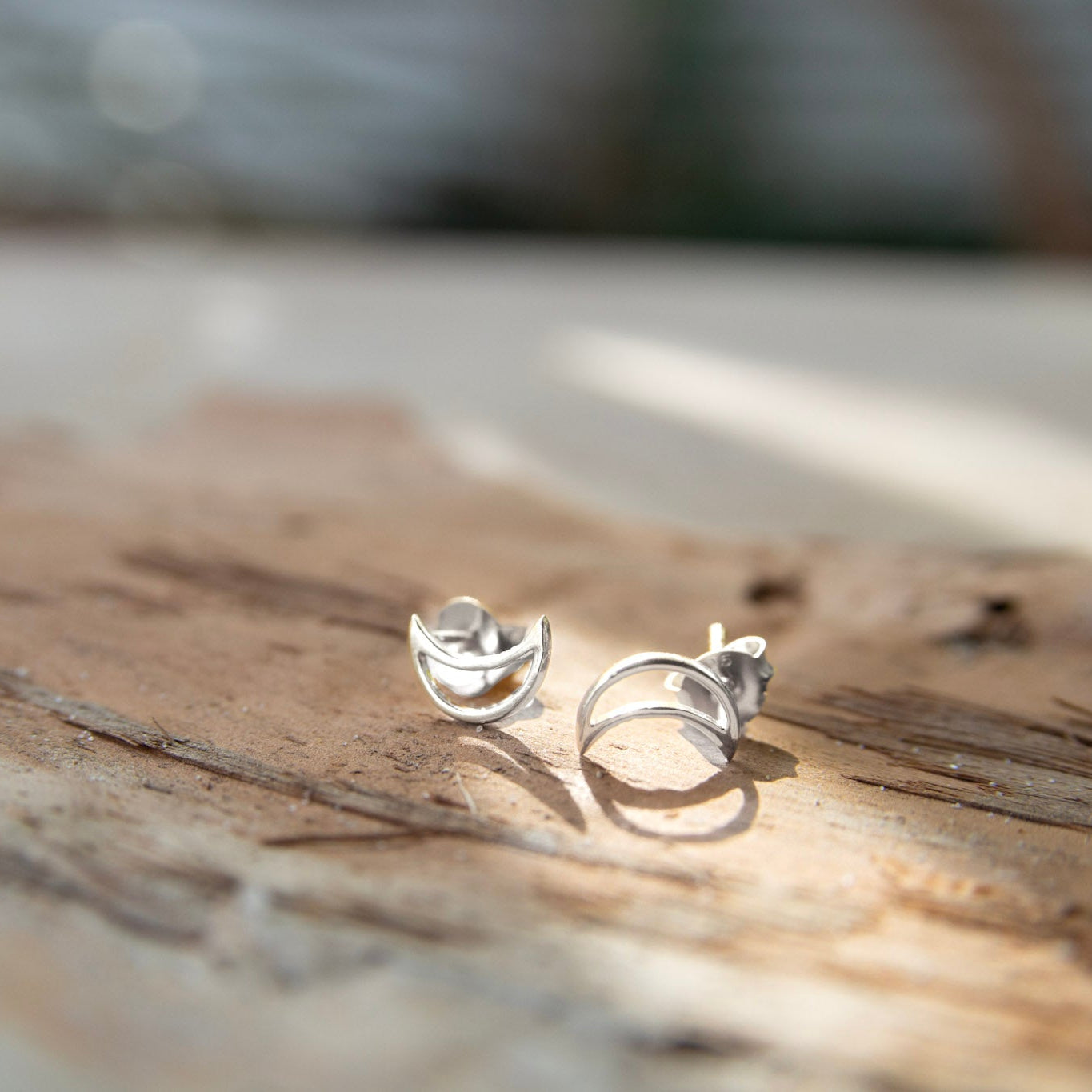 silver moon stud earrings on bark