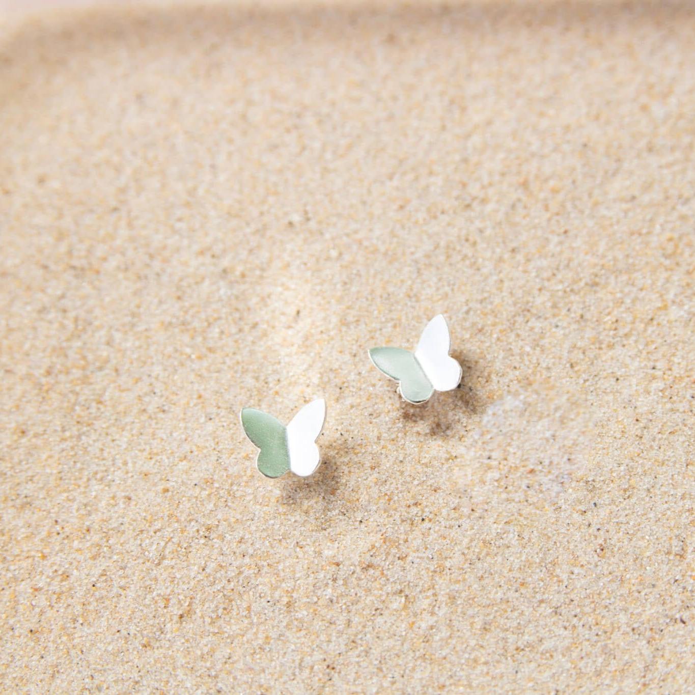 silver butterfly earrings in sand