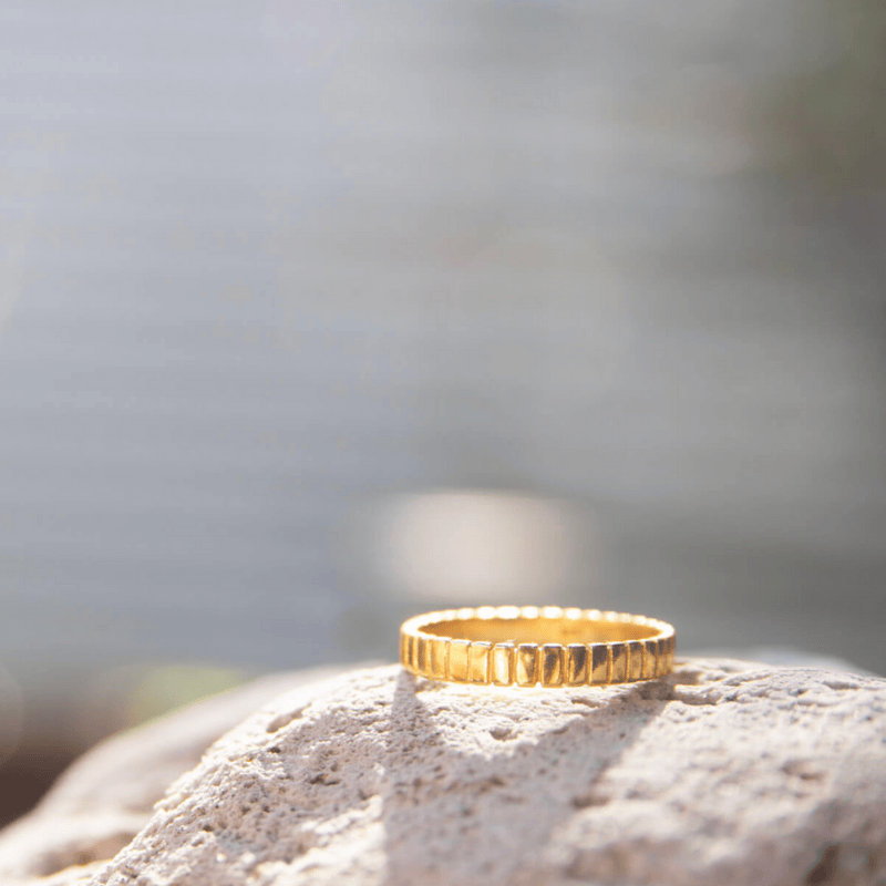 Gold Plated Patterned Ring placed on a rock