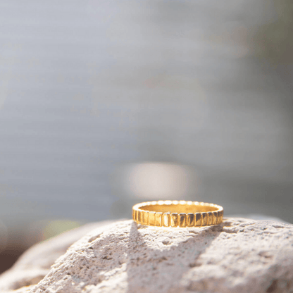 Gold Plated Patterned Ring placed on a rock