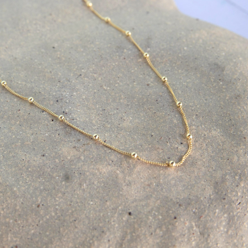 Gold necklace on a textured surface