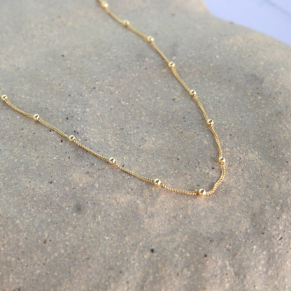 Gold necklace on a textured surface