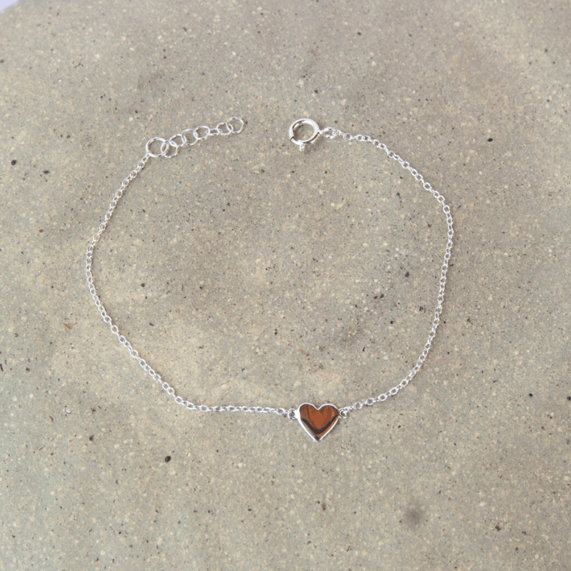silver bracelet with love heart pendant on stone background