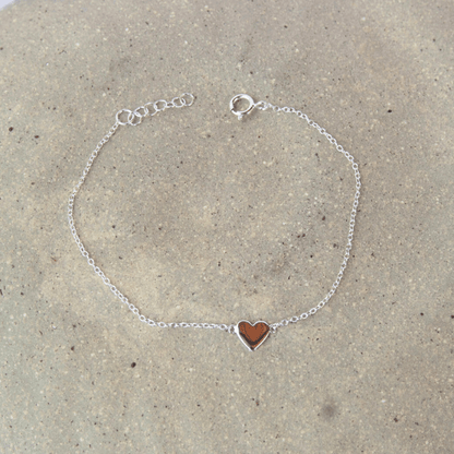 silver bracelet with love heart pendant on stone background