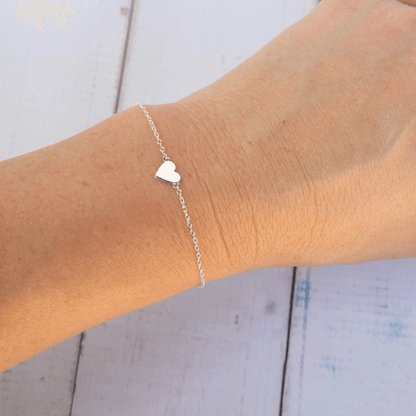 silver love heart bracelet around a wrist