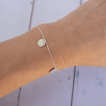 silver bracelet with hammered discs on a woman's wrist