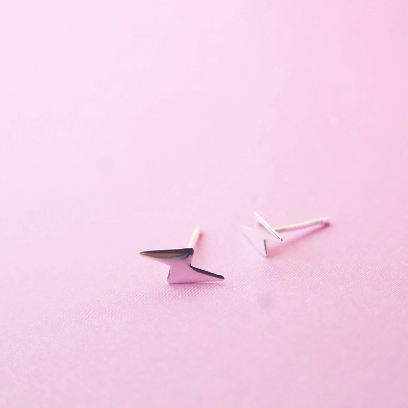 Pair of geometric earrings on a pink background