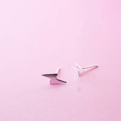 Pair of geometric earrings on a pink background