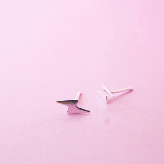 Pair of geometric earrings on a pink background