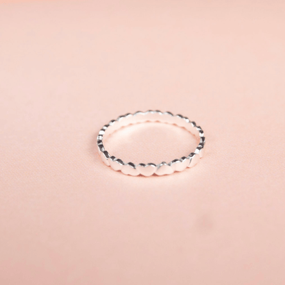 Silver ring on a pink background