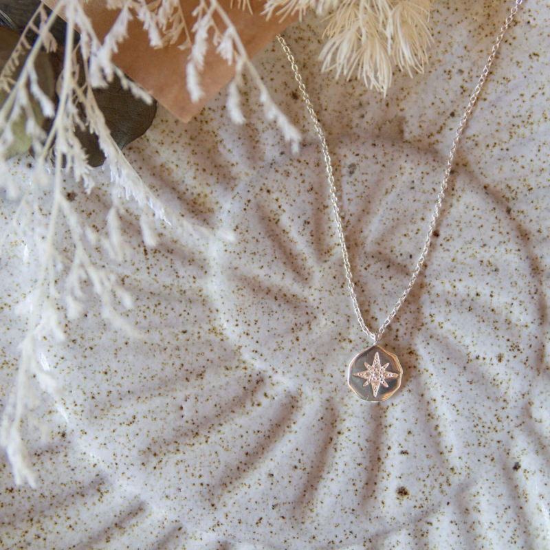 Necklace with a star pendant on a textured surface