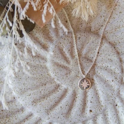 Necklace with a star pendant on a textured surface