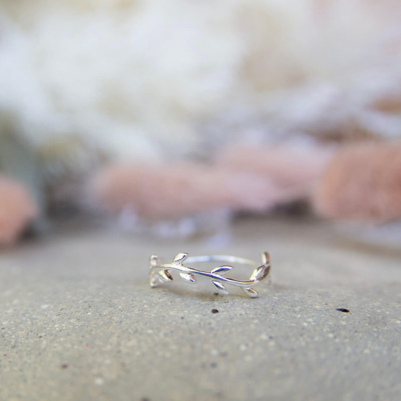 Silver ring with leaf design on a neutral background