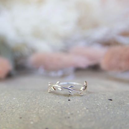 Silver ring with leaf design on a neutral background